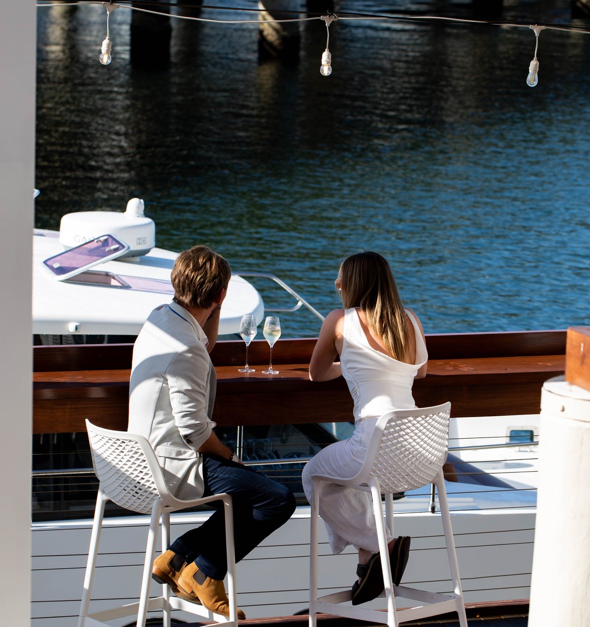 Two guests at the water's edge on the riverside deck